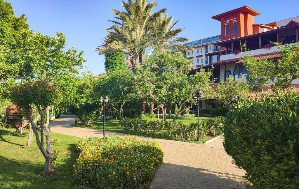 Belconti Resort Hotel dārza ainava ar zaļām puķēm un palmām