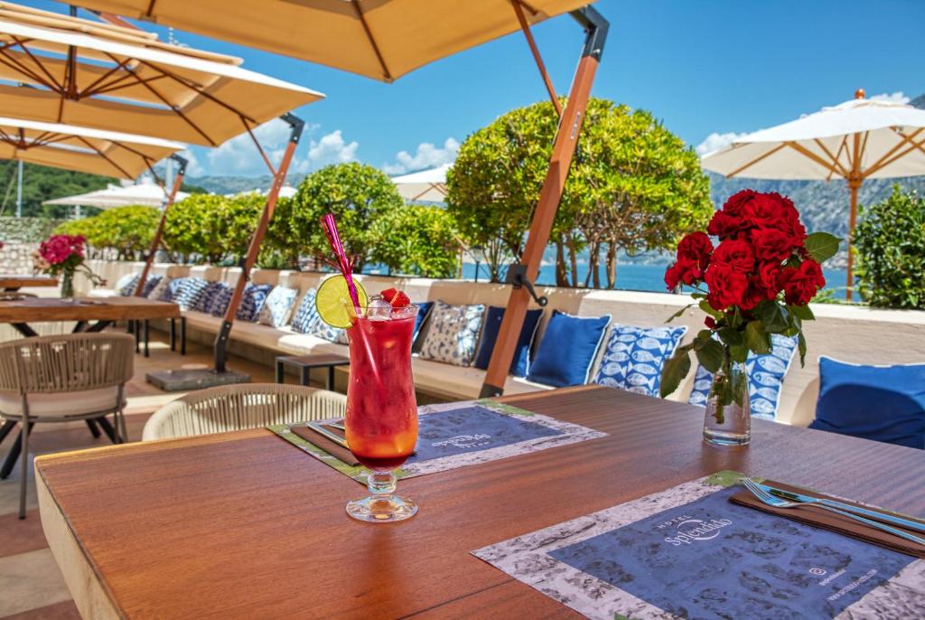Skaists restorāna terases skats ar dzērienu, ziediem un komfortablām sēdvietām. Ideāli piemērots relaksējošai maltītei ārā.