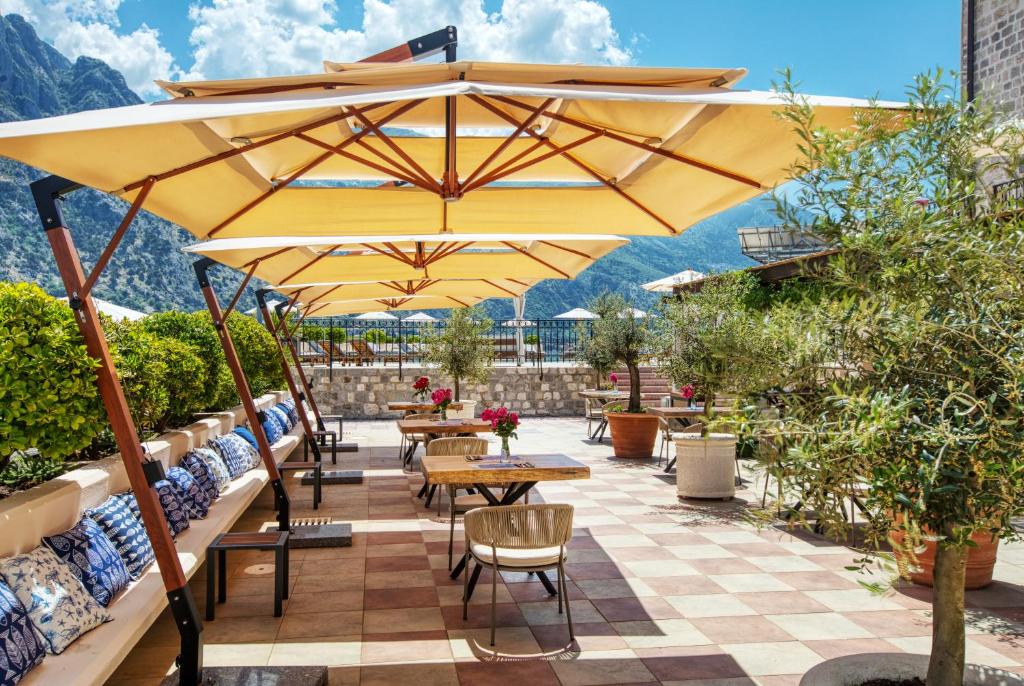 Skaists terases skats ar saules aizsargiem, ziediem un augiem, ideāli piemērots relaksācijai un ēšanai brīvā dabā. Terase piedāvā gleznainus kalnu skatus un mājīgu atmosfēru.