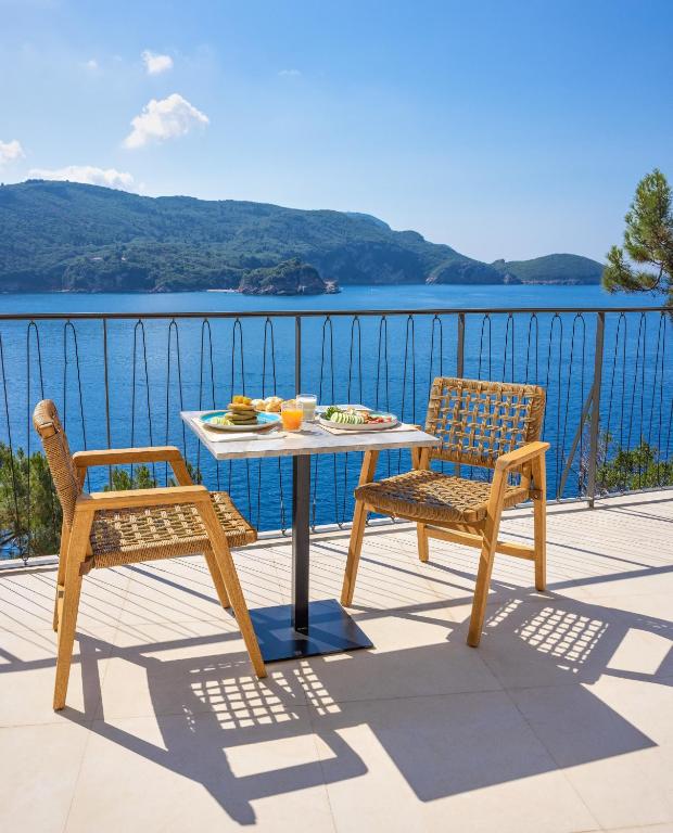 Terase ar skatu uz jūru, kur ir galds un divas krēsli, uz galda atrodas ēdieni un dzērieni. Ideāla vieta relaksācijai un baudīšanai.