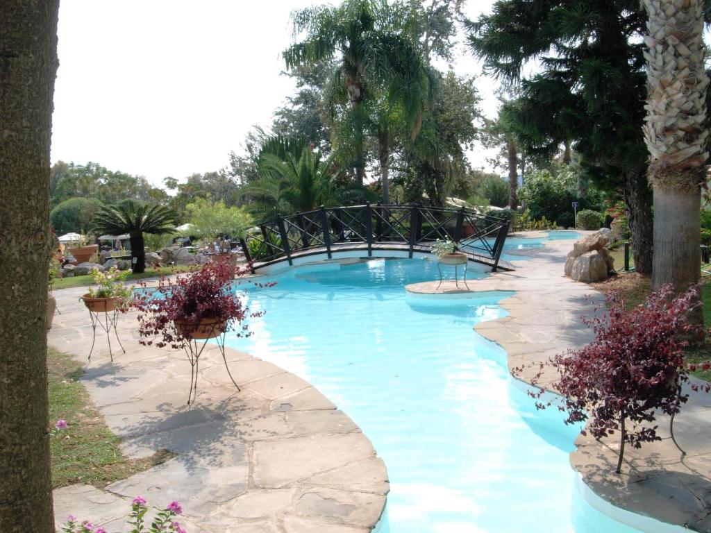 Kalypso Beach viesnīcas peldbaseins ar tiltu un ziediem