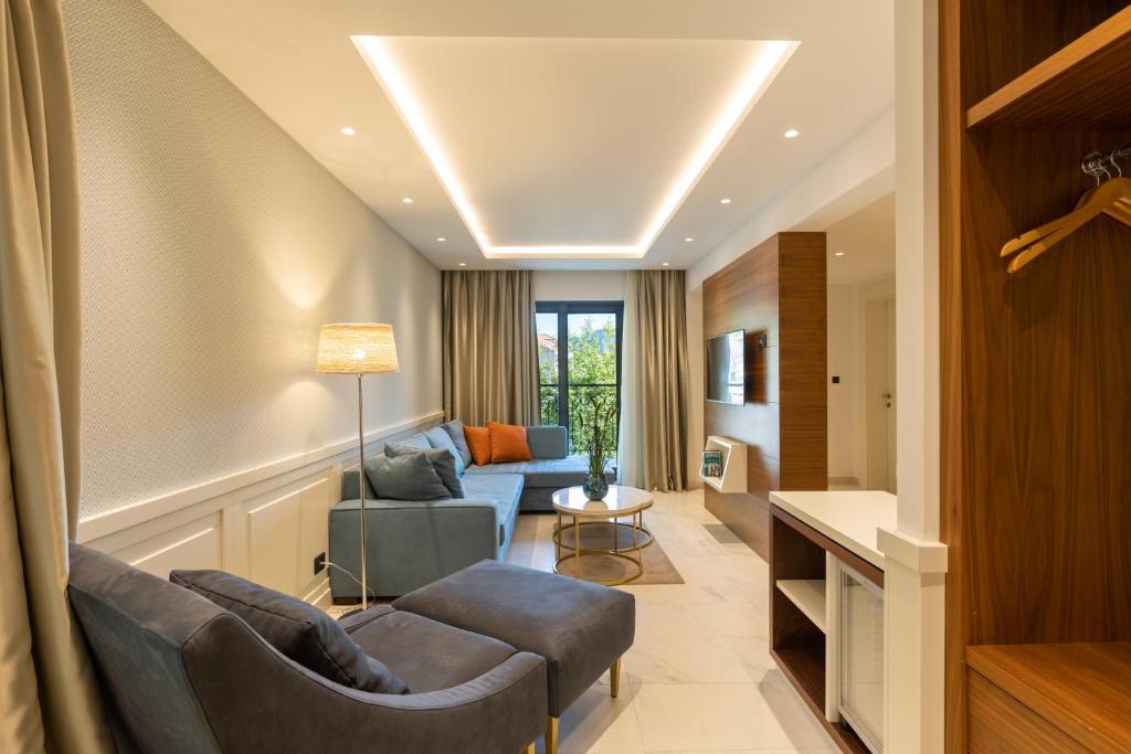 Mūsdienīgs viesnīcas numurs ar plašu dzīvojamo zonu, ērtiem dīvāniem un moderno apgaismojumu. Lielisks skats uz āru caur logiem, kas piepilda telpu ar gaismu.