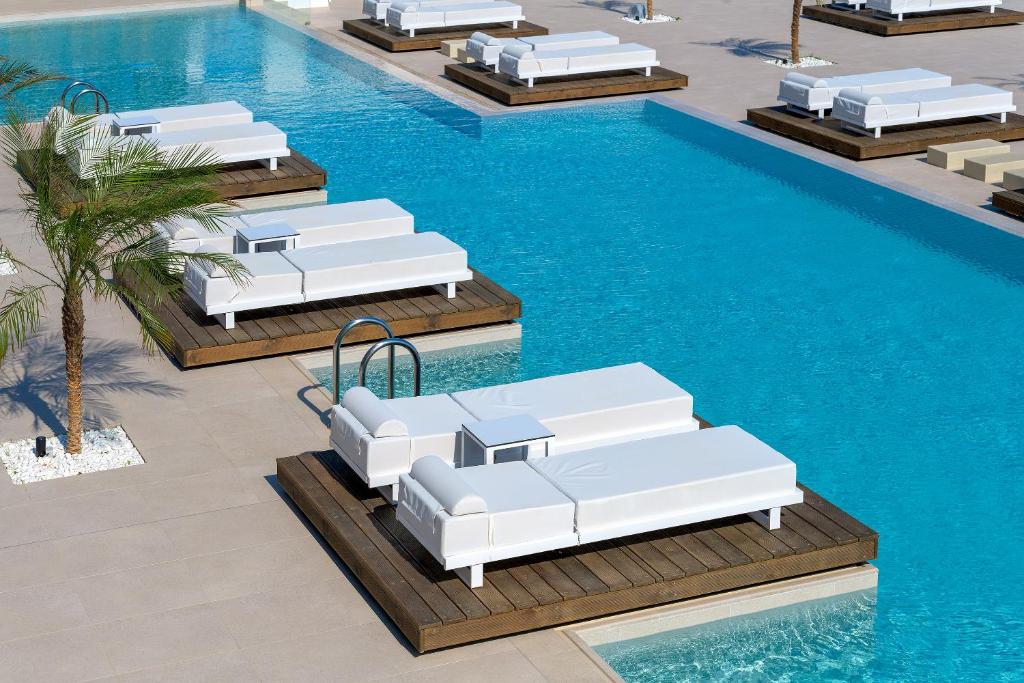 Svaigi balti sauļošanās krēsli pie baseina Sun Beach Resort