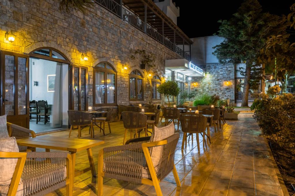 Āra terase ar akmens sienām, apgaismota ar siltām lampām, piedāvā relaksējošu atmosfēru, lai izbaudītu vakara maltīti. Koka galdi un krēsli veido patīkamu vidi, ko ieskauj zaļumi.