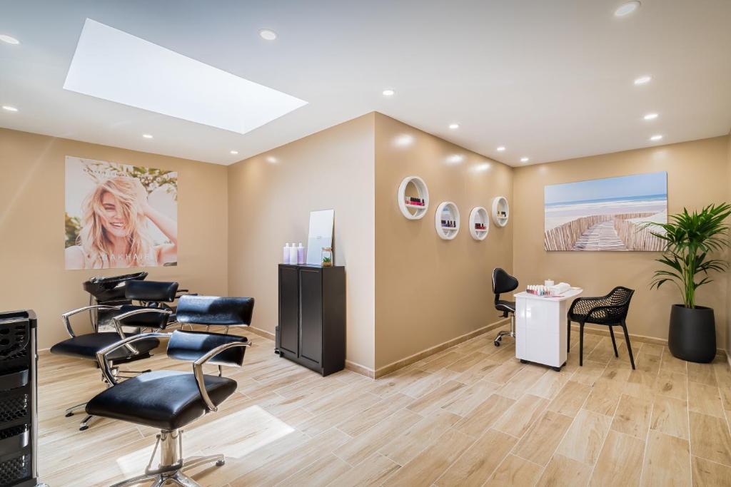 Mūsdienīgs skaistumkopšanas salons ar gaišām sienām, stilīgām frizētavām un manikīra zonu. Telpa ir apgaismota ar dabisko gaismu un dekorēta ar modernām fotogrāfijām.