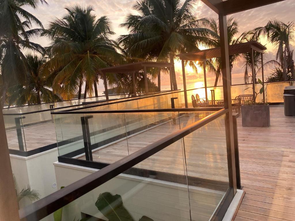 Saulriets pie TOA Hotel & Spa terases ar palmu skatu.