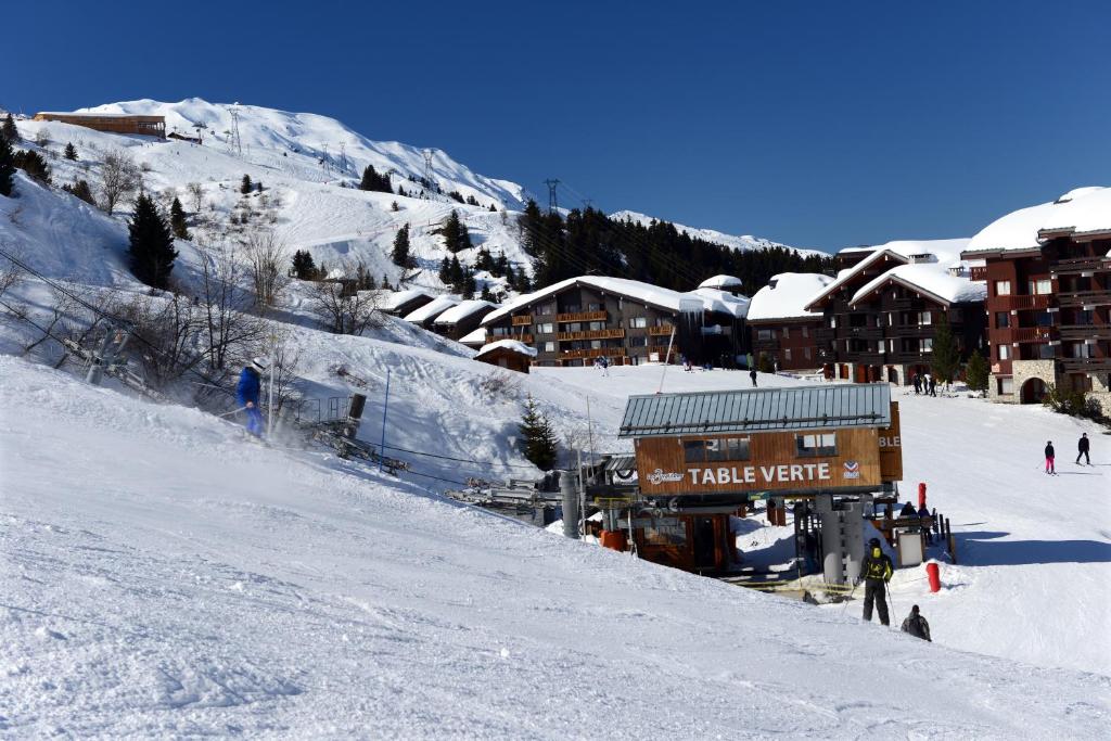 Sniega kūrorts ar slēpošanas pacēlāju un kalnu ainavu, kas nodrošina lieliskas ziemas aktivitātes. Skats uz viesnīcām un slēpotājiem ziemas sezonā.