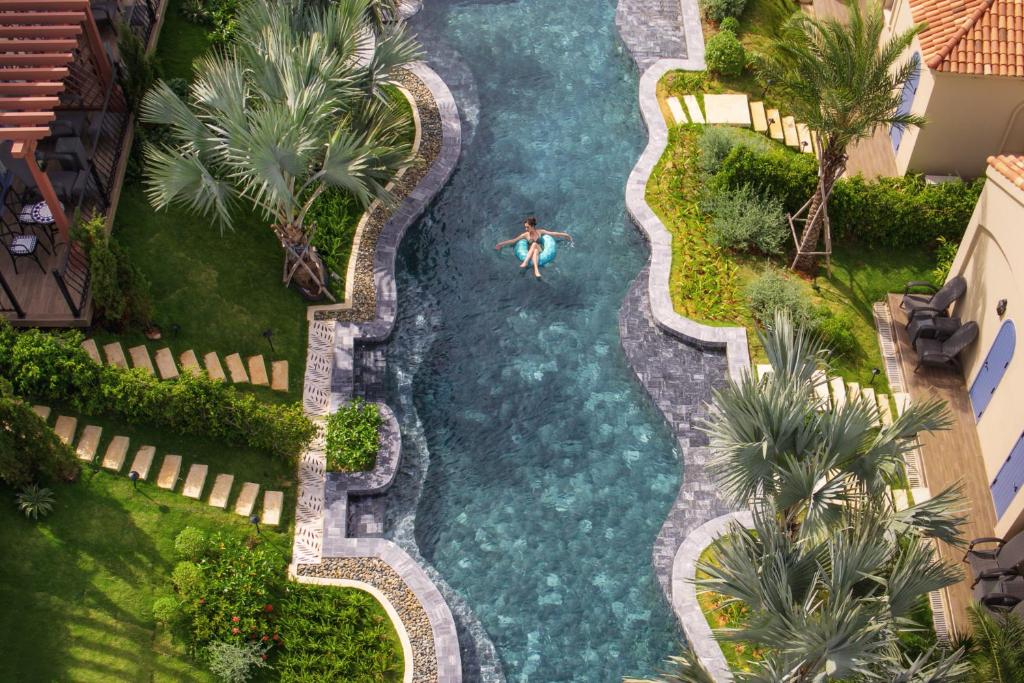 Centara Mirage Resort Mui Ne baseins ar tropiskiem augiem