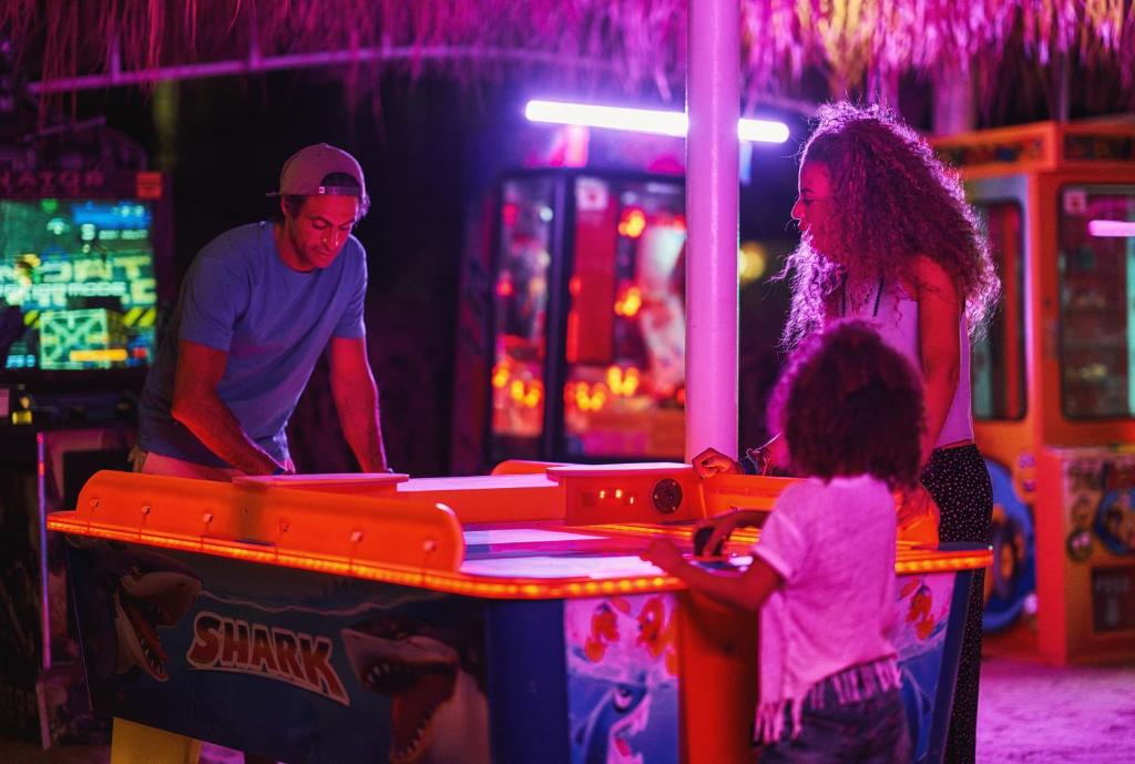 Desert Rose Resort arcade with family playing air hockey