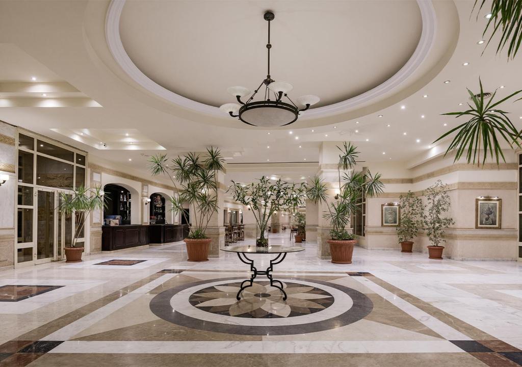 Elegants vestibils Sindbad Club viesnīcā ar augstiem griestiem un ziediem.