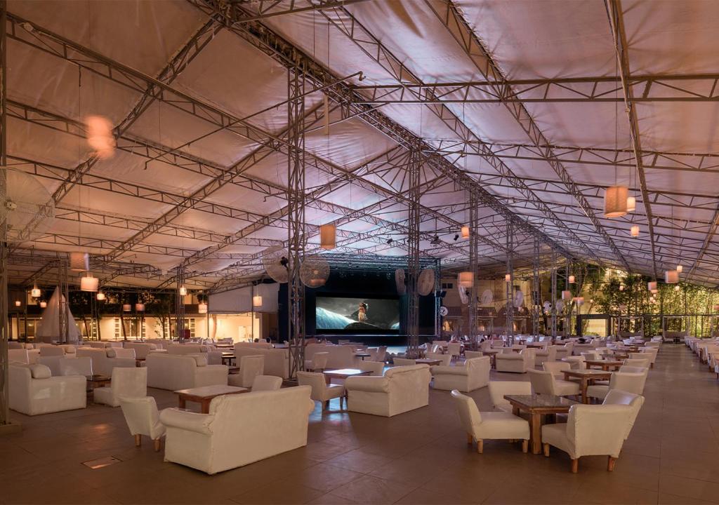 Sindbad Club atklātā kino zāle ar baltām mēbelēm un ekrānu.