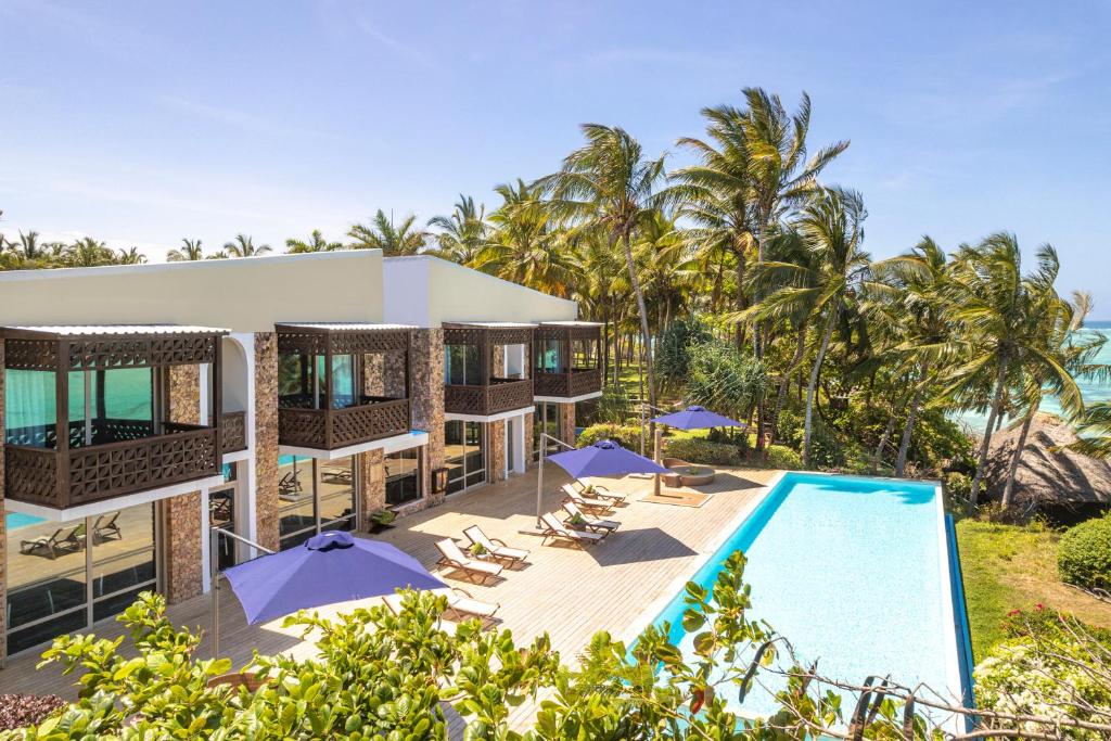 Melia Zanzibar piekrastē ar baseinu un palmām saulainā dienā.