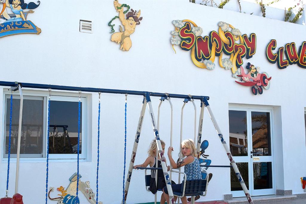Bērni šūpojas pie Snoopy Club Maritim Jolie Ville Resort & Casino.