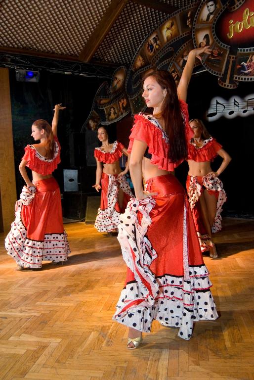 Dejas priekšnesums pie Maritim Jolie Ville Resort & Casino ar dejotājām sarkanās kleitās.