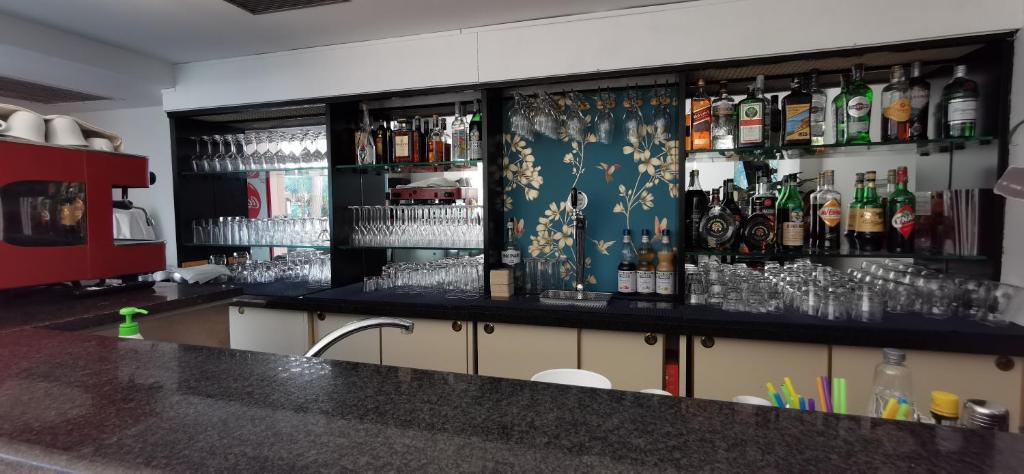 Bārs ar plašu dzērienu klāstu un elegantu interjeru, kurā redzami glāzes un alkohola pudeles.