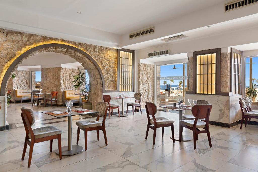 Elegantā ēdamzāle viesnīcā Pickalbatros Citadel Resort ar skatu uz jūru.