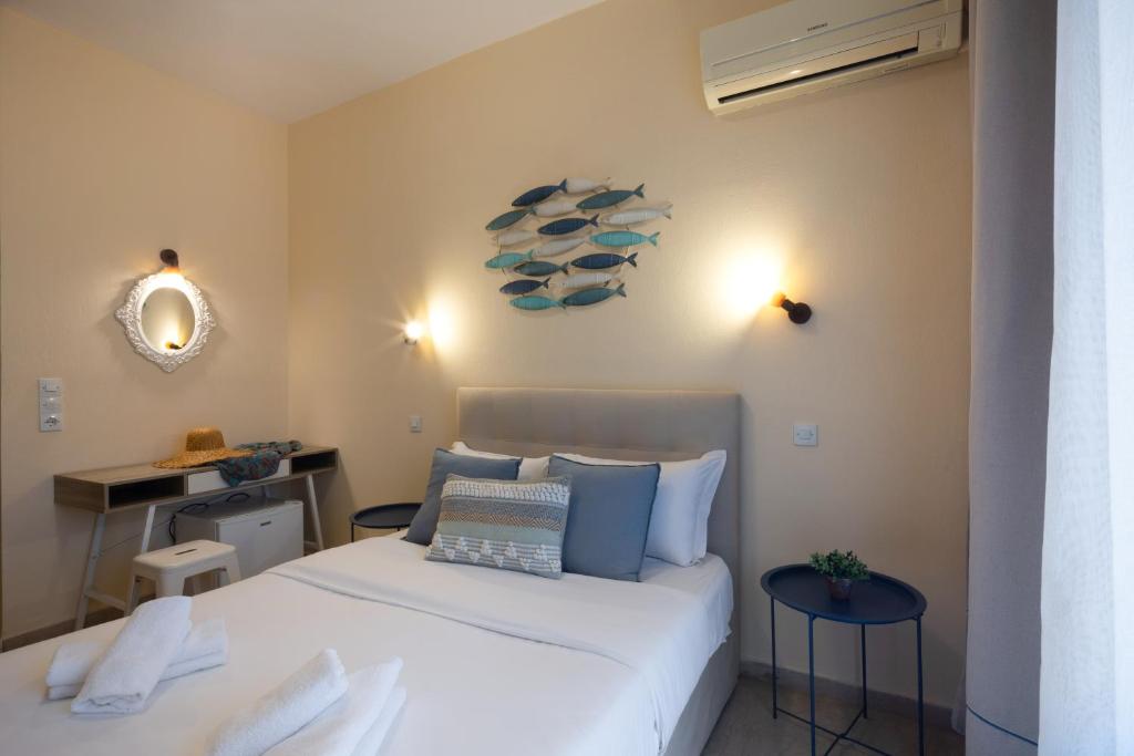 Mūsdienīga guļamistaba ar ērtu gultu, dekoratīviem spilveniem un sienu ar zilu zivs motīvu. Telpā ir gaismas avoti un eleganta spogulis, kas rada mājīgu atmosfēru.