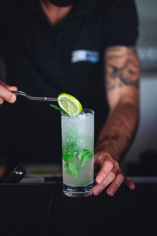 Bārmenis rūpīgi gatavo atspirdzinošu kokteili ar laimu un piparmētrām Janna 'e Sole Resort bārā.