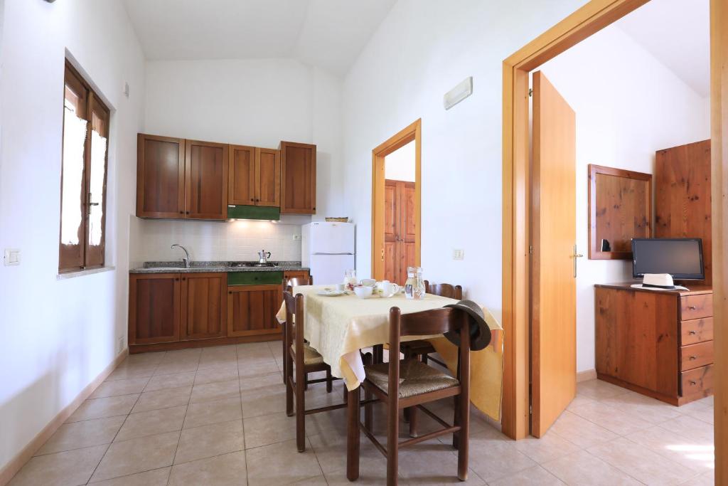 Mūsdienīga virtuve ar koka mēbelēm un ēdamgaldu, kas piedāvā mājīgu atmosfēru. Telpā ir pieejams televizors un gaismas krāsu palete.