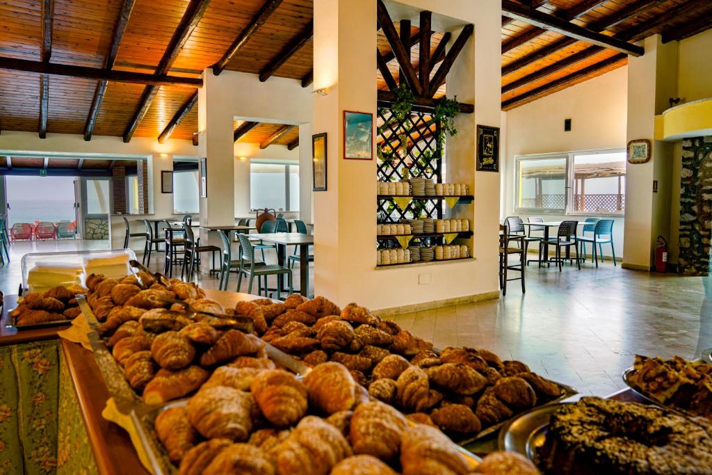 Kafejnīca ar mājīgu interjeru un kaskādi no svaigiem konditorejas izstrādājumiem, ieskaitot kruasānus un kūkas, aicina apmeklētājus baudīt gardas brokastis. Logi nodrošina skatu uz jūru, radot atpūtas atmosfēru.