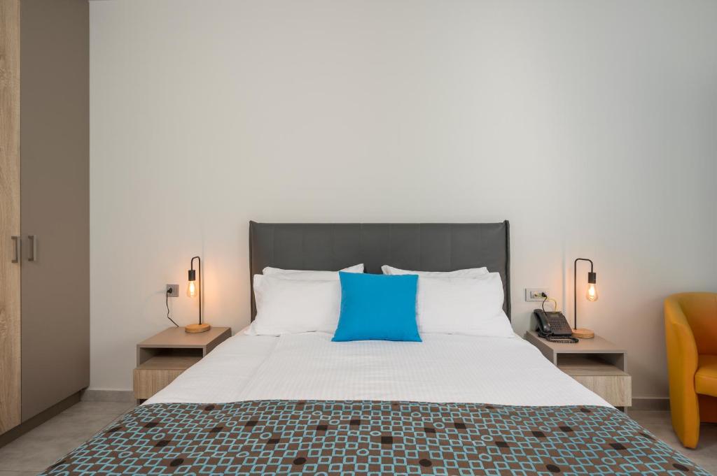 Mūsdienīga guļamistaba ar ērtu gultu, spilvenu un koka skapjiem. Interjeru papildina dzeltena krēslu un gaišas apgaismojuma detaļas.