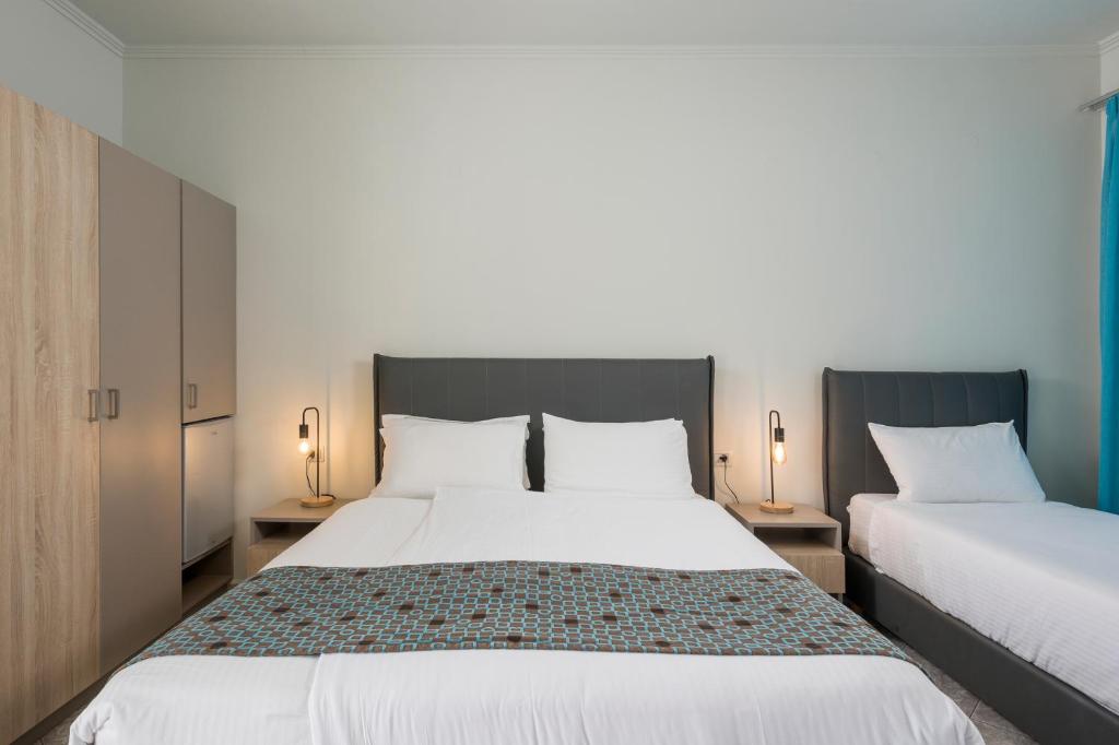 Mūsdienīga viesnīcas istaba ar divām gultām, elegantu apgaismojumu un koka skapjiem. Ideāla vieta atpūtai un komfortam.