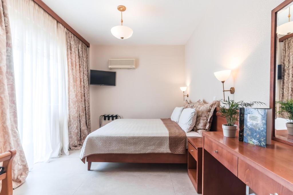 Mūsdienīgs viesnīcas numurs ar divguļamo gultu, televizoru un dabīgu apgaismojumu. Telpā ir eleganti aizkari, koka mēbeles un dekoratīvas augu kompozīcijas.