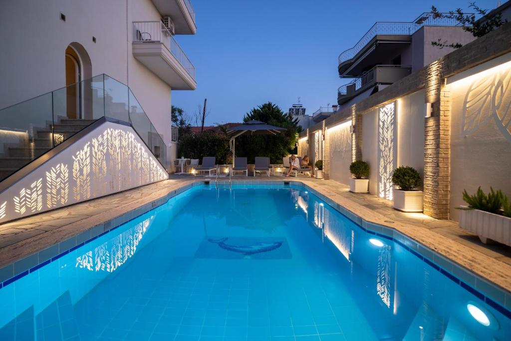 Mūsdienīgs peldbaseins ar apgaismojumu un ērtām atpūtas zonām, piemērots relaksācijai vakara stundās. Apkārt esošā arhitektūra un augu elementi rada patīkamu atmosfēru.