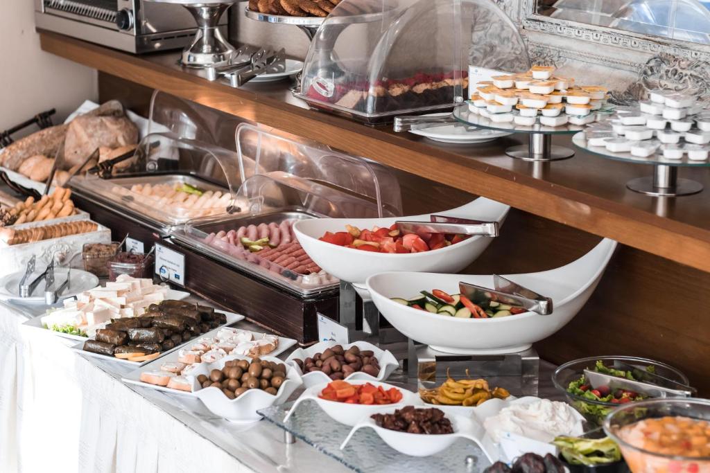 Bagātīgs brokastu bufete ar dažādiem ēdieniem, tostarp gaļas izstrādājumiem, salātiem un desertiem. Ideāla izvēle gardēžiem, kas meklē daudzveidību.