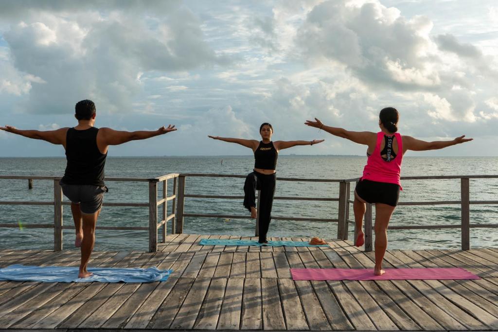 Joga nodarbība pie Cancún Bay Resort, saulē un jūras viļņu fonā