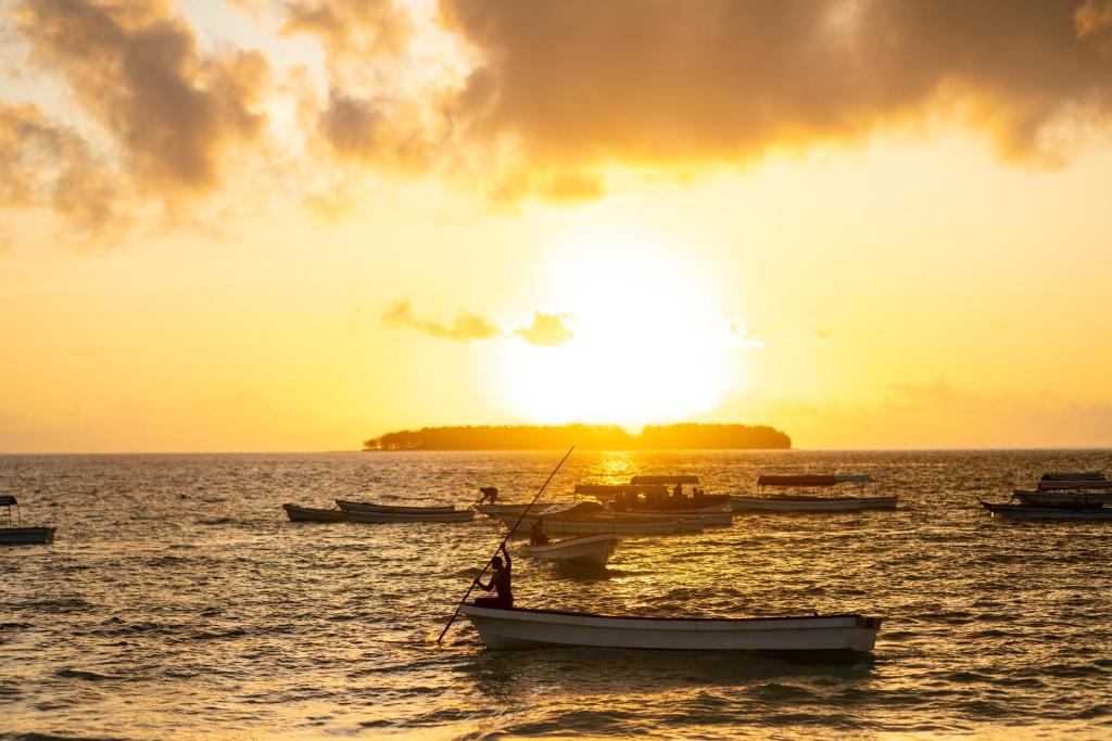 Saulriets pie The Mora Zanzibar ar laivām jūrā