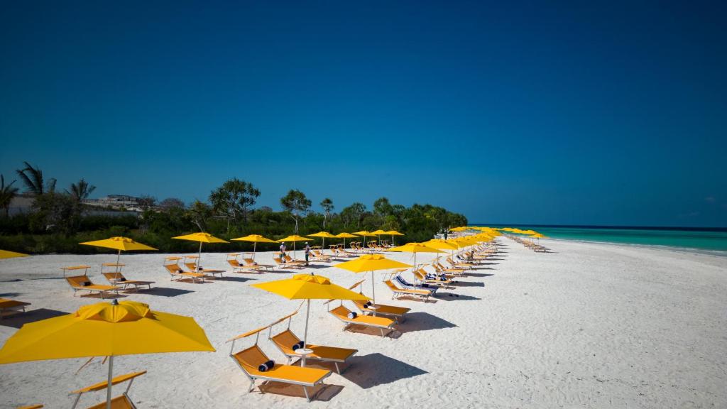 Pludmale ar dzelteniem saulessargiem pie The Mora Zanzibar viesnīcas.