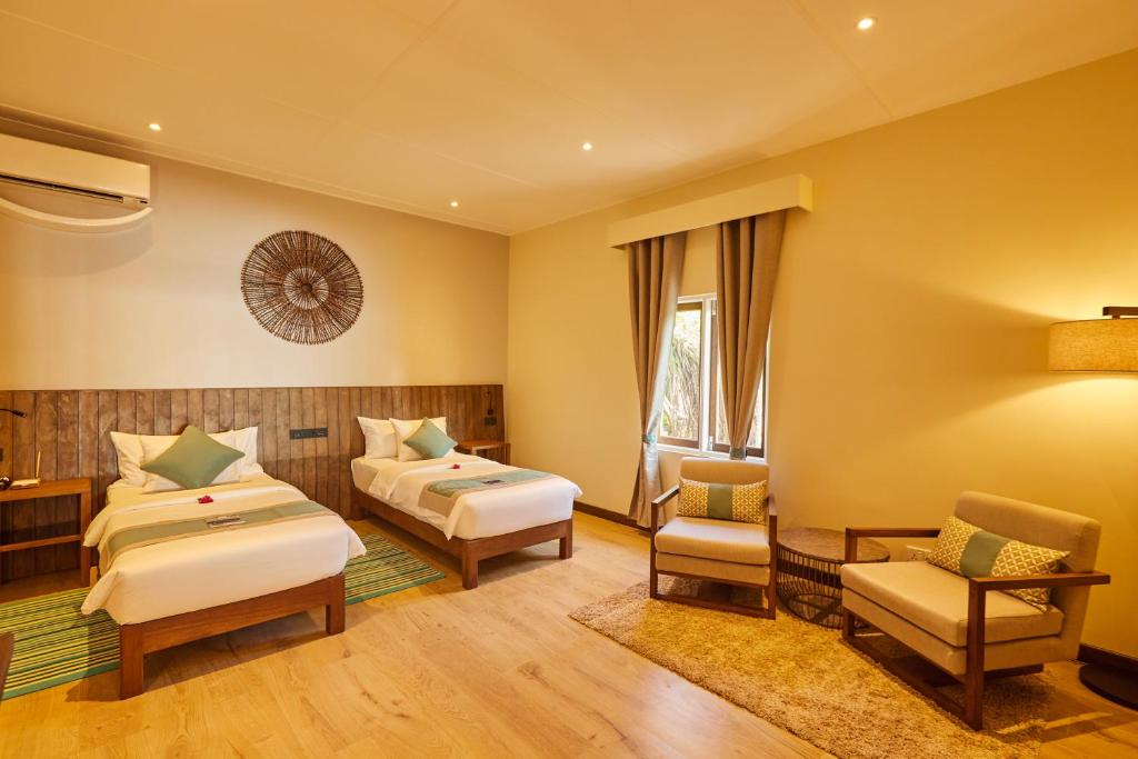 Mūsdienīgs viesnīcas numurs ar divām atsevišķām gultām, koka apdari un ērtu sēdvietu stūri. Gaismas un dabiskā apgaismojuma harmonija veido relaksējošu atmosfēru.