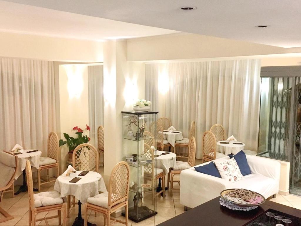 Mūsdienīgs kafejnīcas interjers ar elegantām galdiņiem un krēsliem, kurā ir gaiši toņi un dekoratīvas detaļas. Telpas atmosfēra ir ērta un aicinoša.