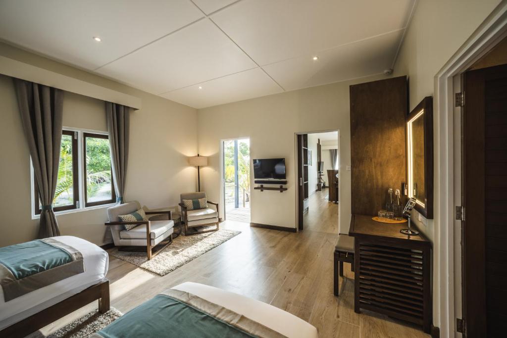 Mūsdienīgs viesnīcas numurs ar divām gultām, ērtām atpūtas krēslām un piekļuvi terasei. Telpa ir gaiša un plaša, ar modernu interjeru un dabisko apgaismojumu.