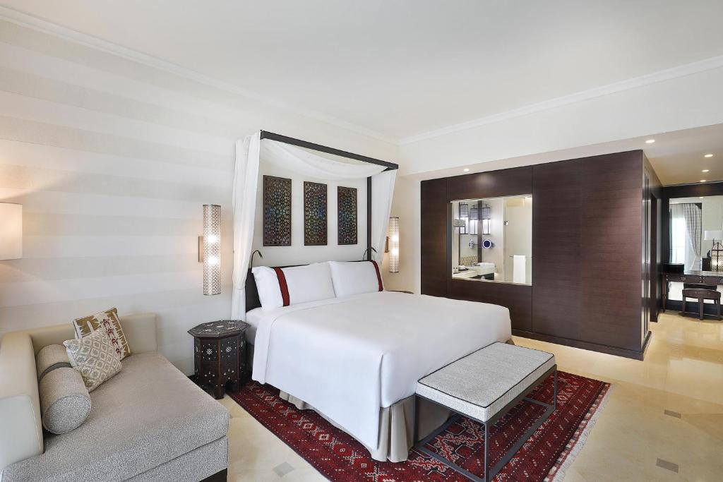 Mūsdienīgs viesnīcas numurs ar ērtu gultu, stilu un eleganci. Telpā ir arī dīvāns un dekoratīvi elementi, kas piešķir siltumu un mājīgumu.