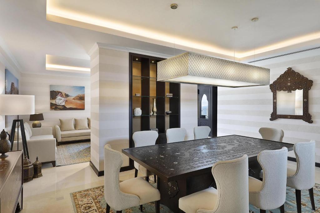 Mūsdienīga ēdamistaba ar elegantu galdu un stilīgām krēslām, papildināta ar izsmalcinātu apgaismojumu un dekoratīviem elementiem. Interjers ir gaišs un viesmīlīgs, radot patīkamu atmosfēru.