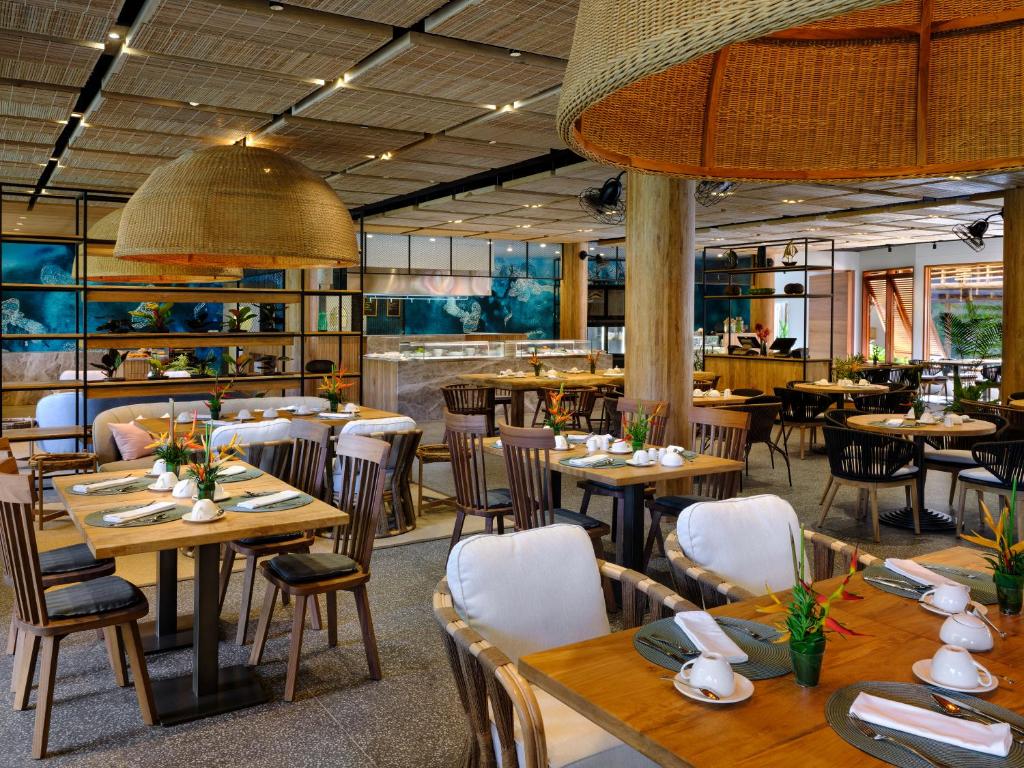 Moderns restorāns ar stilīgām koka mēbelēm un pievilcīgu interjeru, kas ietver zaļumus un radošus dekora elementus. Telpa ir gaiša un plaša, radot patīkamu atmosfēru.