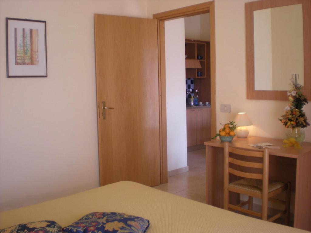 Gaiša un mājīga viesnīcas istaba ar koka durvīm, rakstāmgaldu un nelielu virtuvi. Interjers ir vienkāršs, ar gleznām un ziediem uz galda.