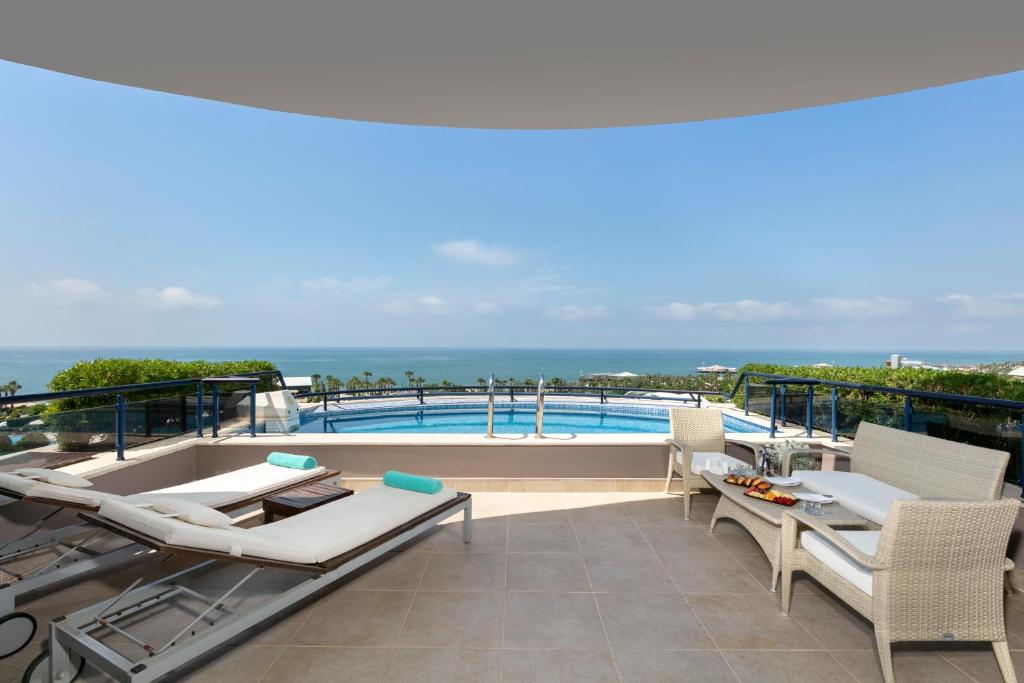 Susesi Luxury Resort terase ar skatu uz jūru un baseinu