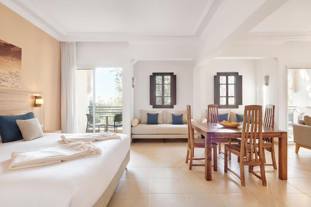 Moderns viesnīcas numurs ar gultu, ēdamgaldu un atpūtas zonu, kas piedāvā dabīgu apgaismojumu un patīkamu atmosfēru. Interjers ir gaišs un elegants, radot mājīgu sajūtu.