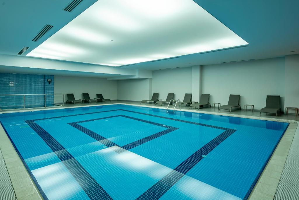 Iekštelpu baseins Megasaray Westbeach Antalya ar atpūtas krēsliem.