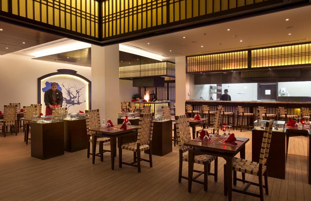 Restorāns Sunrise Grand Select Montemare Resort ar elegantām galdiem un apgaismojumu.