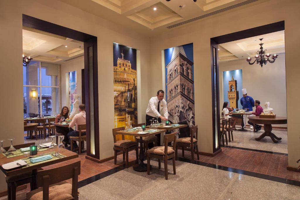 Grezns restorāns Sunrise Grand Select Montemare Resort ar viesmīli un viesiem.