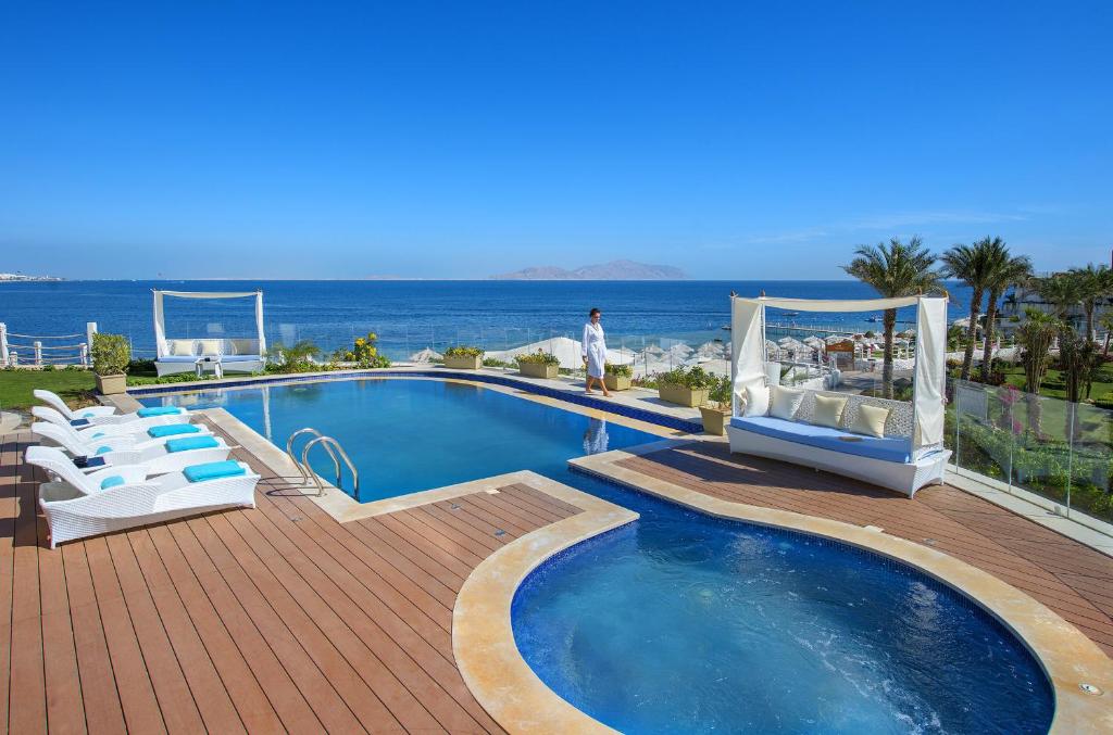 Relaksējoša atmosfēra pie baseina Sunrise Arabian Beach Resort, skats uz jūru.