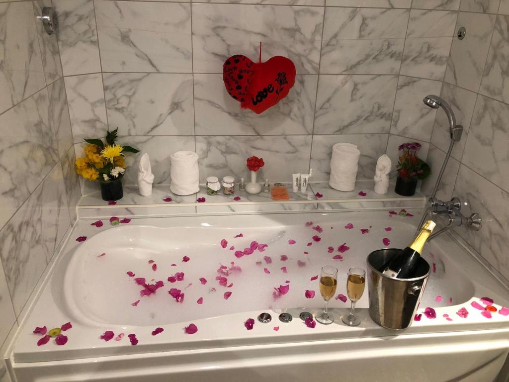 Romantisks vanna ar ziedlapiņām, šampanieti un ziediem. Ideāla atmosfēra relaksācijai un svinībām.