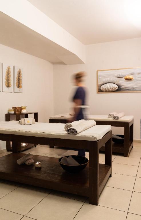 Skaista spa telpa ar masāžas galdiem un relaksējošu atmosfēru. Interjerā ir izmantoti neitrāli toņi, radot mierīgu vidi.