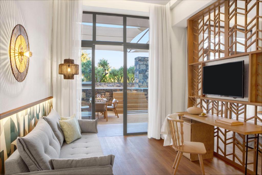 Mūsdienīgs numurs Mirabello Bay Luxury Resort ar terasi un modernu dizainu.
