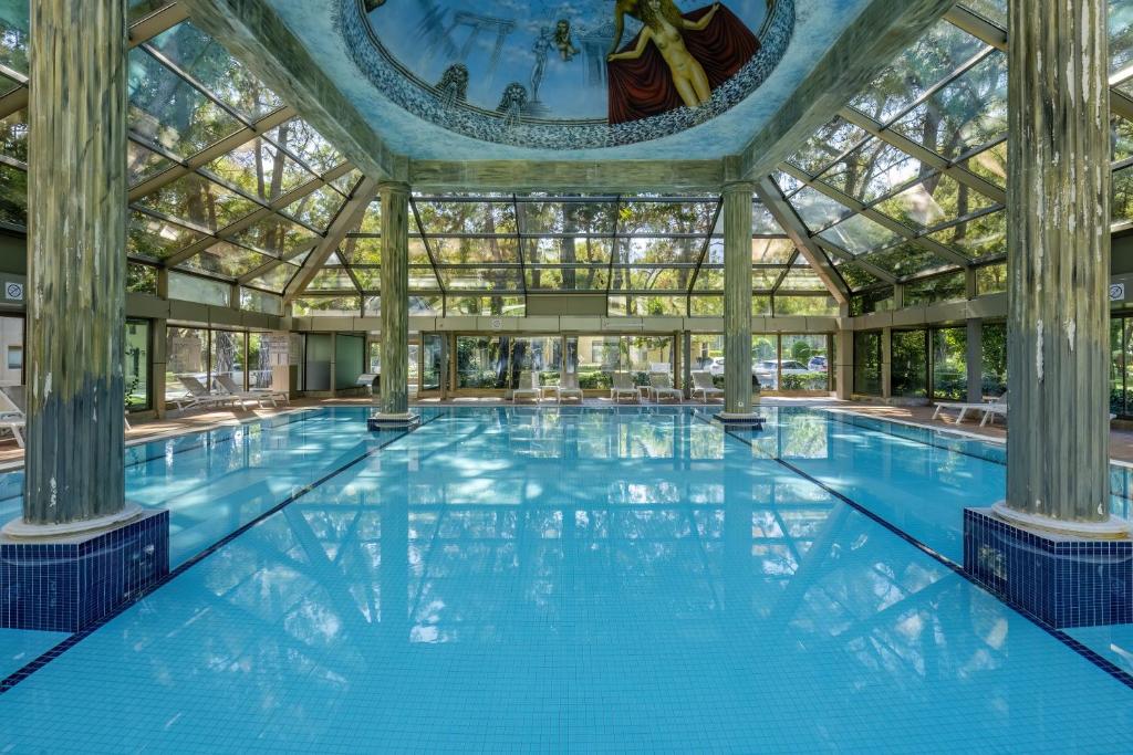 Iekštelpu baseins Mirada Del Mar Hotel ar stikla jumtu un skatu uz dārzu.