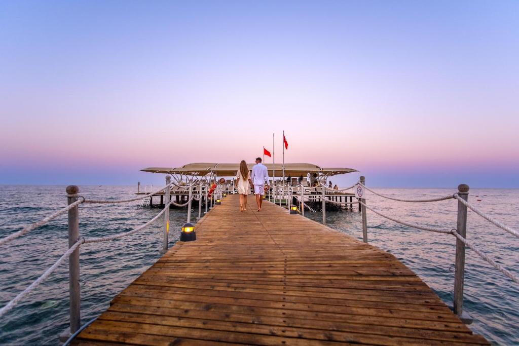 Pāris dodas pa koka piestātni pie Mirada Del Mar Hotel, piekrastē.